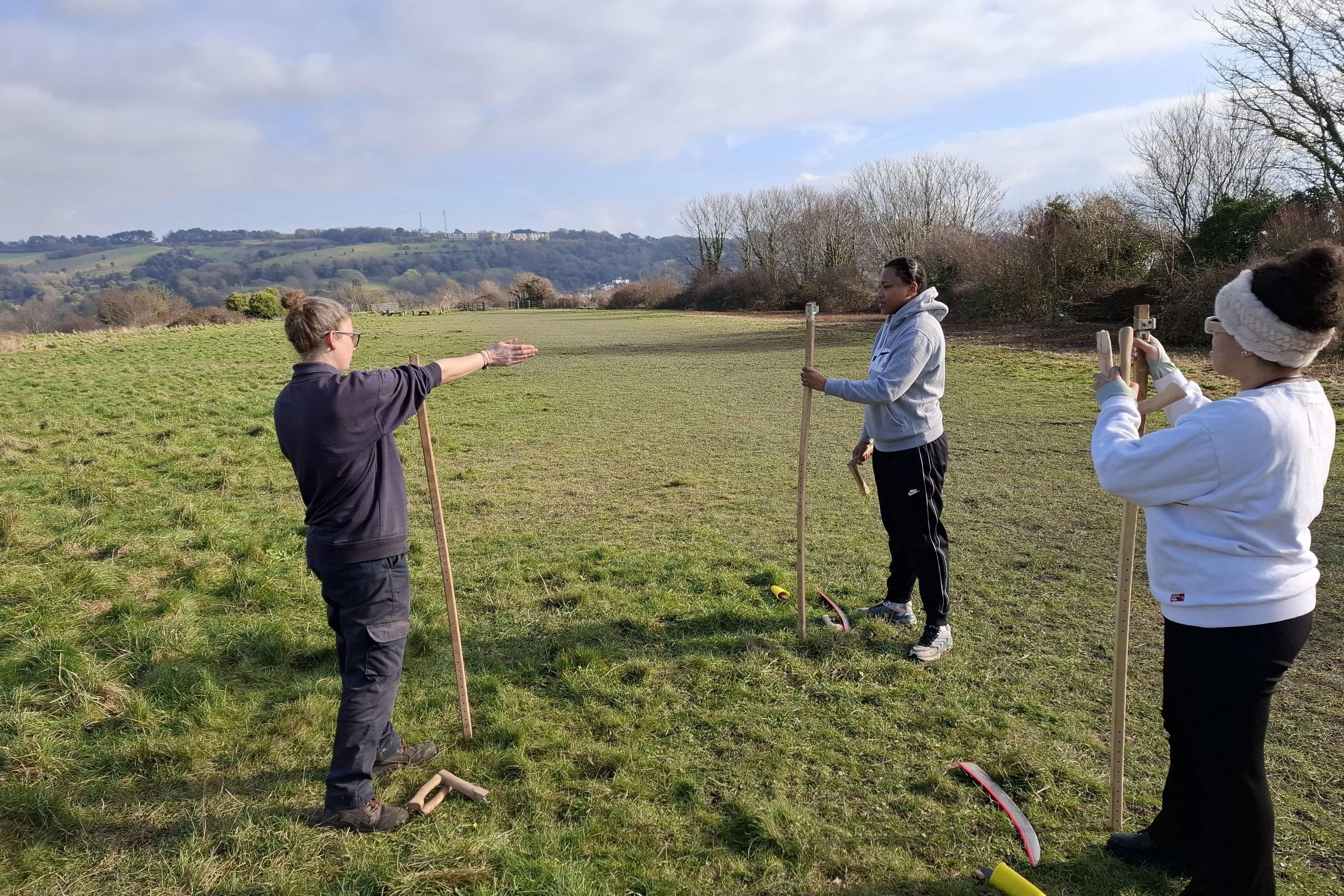 Ranger Miranda teaching Wild Futures attendees the art of scything.